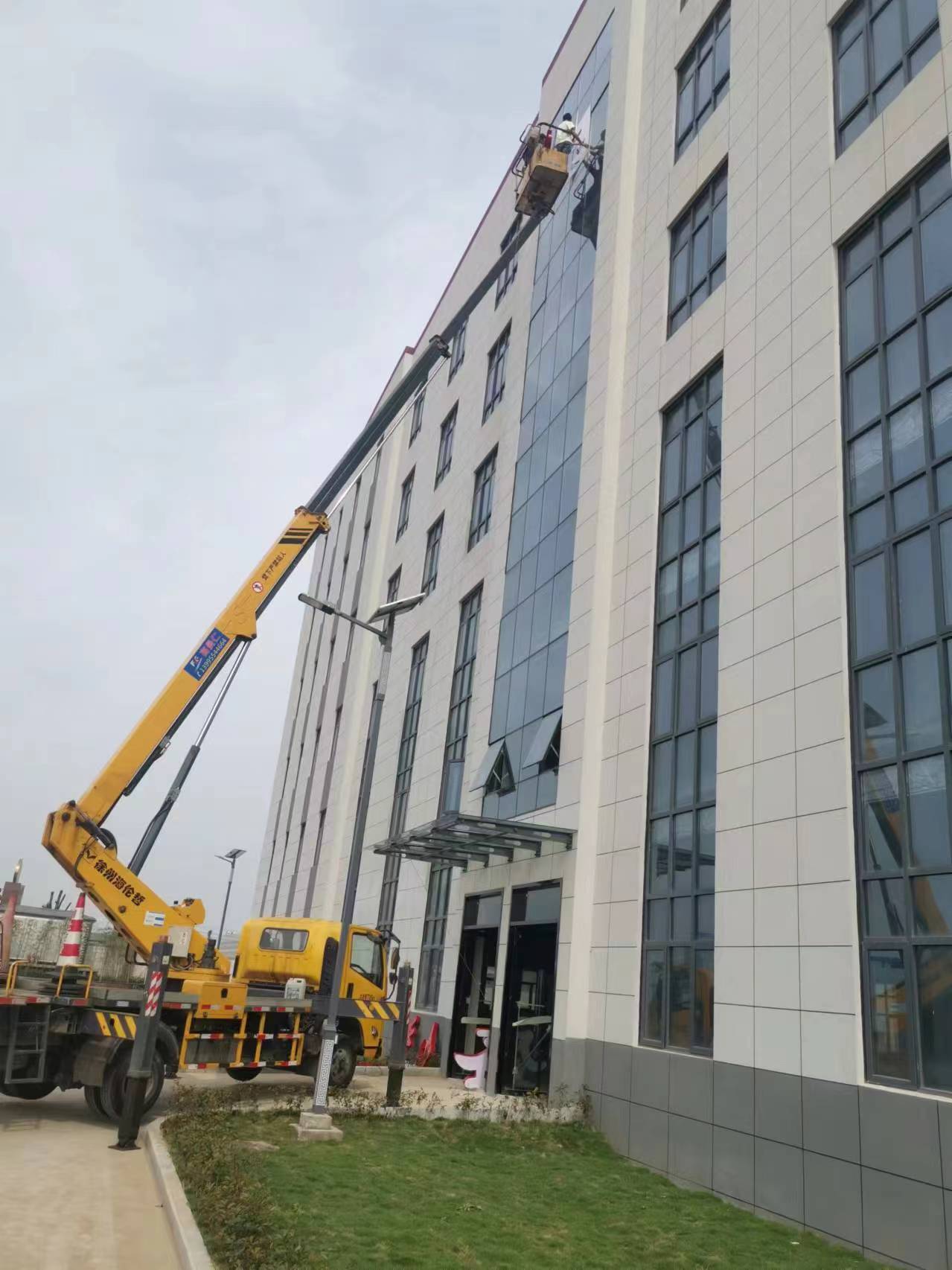 24米升降車高層樓外墻換玻璃施工現(xiàn)場(chǎng)