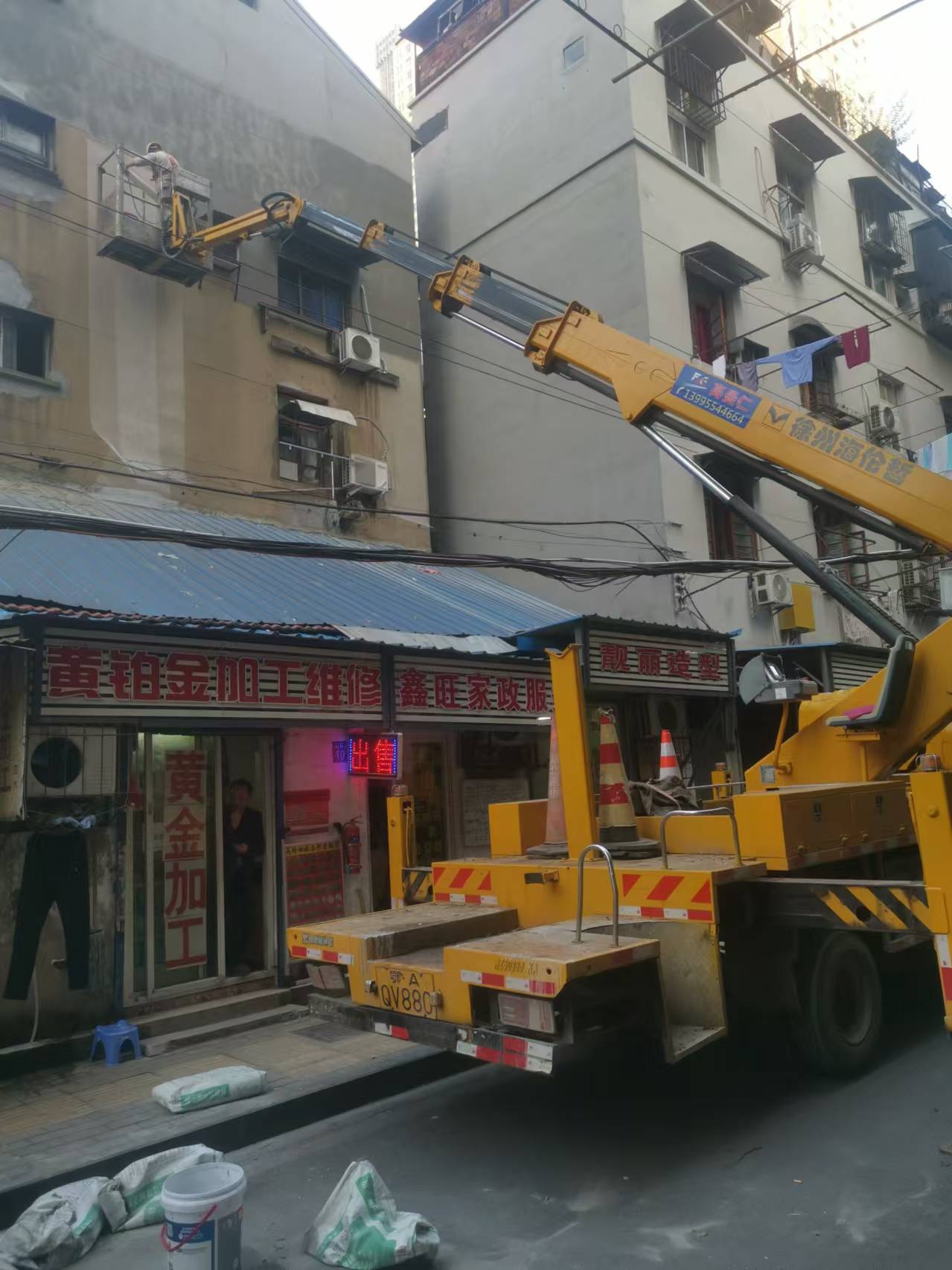 22米登高車載人粉刷外墻施工現(xiàn)場(chǎng)